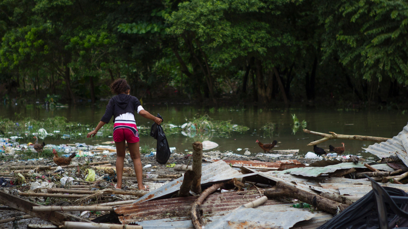 Picture taken in the flooded neighbourhood of La Puya, in Santo Domingo on October 4, 2016 after the passage of Hurricane Matthew through Hispaniola — the island that the Dominican Republic shares with Haiti. Matthew, a Category Four hurricane, slammed into the Dominican Republic and Haiti Tuesday, triggering major floods and forcing thousands to flee the path of the storm that has claimed at least three lives in each country. (Image: Getty)